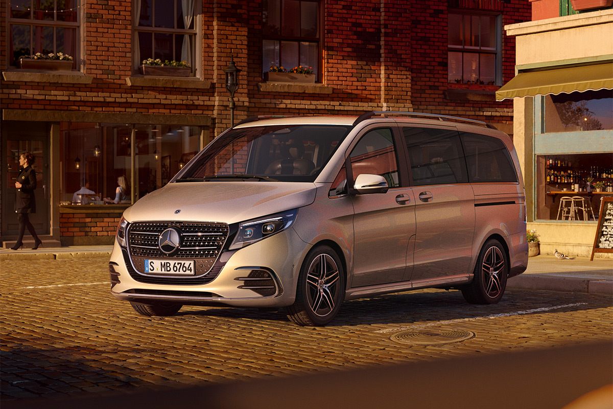 Auf dem Bild steht ein silberfarbener Van der Marke Mercedes‑Benz auf einer gepflasterten Straße. Das Fahrzeug ist leicht seitlich nach rechts gewendet, sodass Front und rechte Seite gut zu sehen sind. Die Scheiben sind dunkel getönt, und das Fahrzeug hat schwarze Felgen mit einem mehrspeichigen Design.