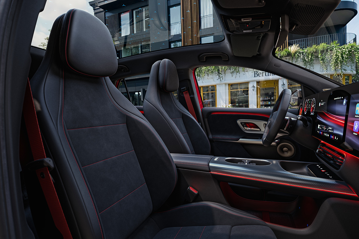 Innenraum eines Mercedes Elektro SUV mit zwei Vordersitzen digitalem Fahrerdisplay grossem Touchscreen Mittelkonsole und Panoramadach.