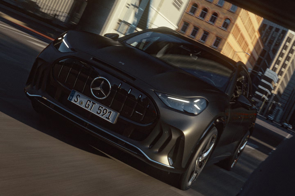 Frontansicht eines grauen Mercedes AMG GT SUV bei schneller Fahrt durch eine Stadt mit markantem Kuehlergrill LED Scheinwerfern und dynamischer Linienfuehrung