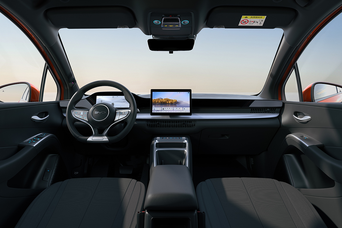 Blick vom Fond auf den Fahrzeuginnenraum mit Lenkrad digitalem Kombiinstrument zentralem Touchdisplay und zwei Vordersitzen