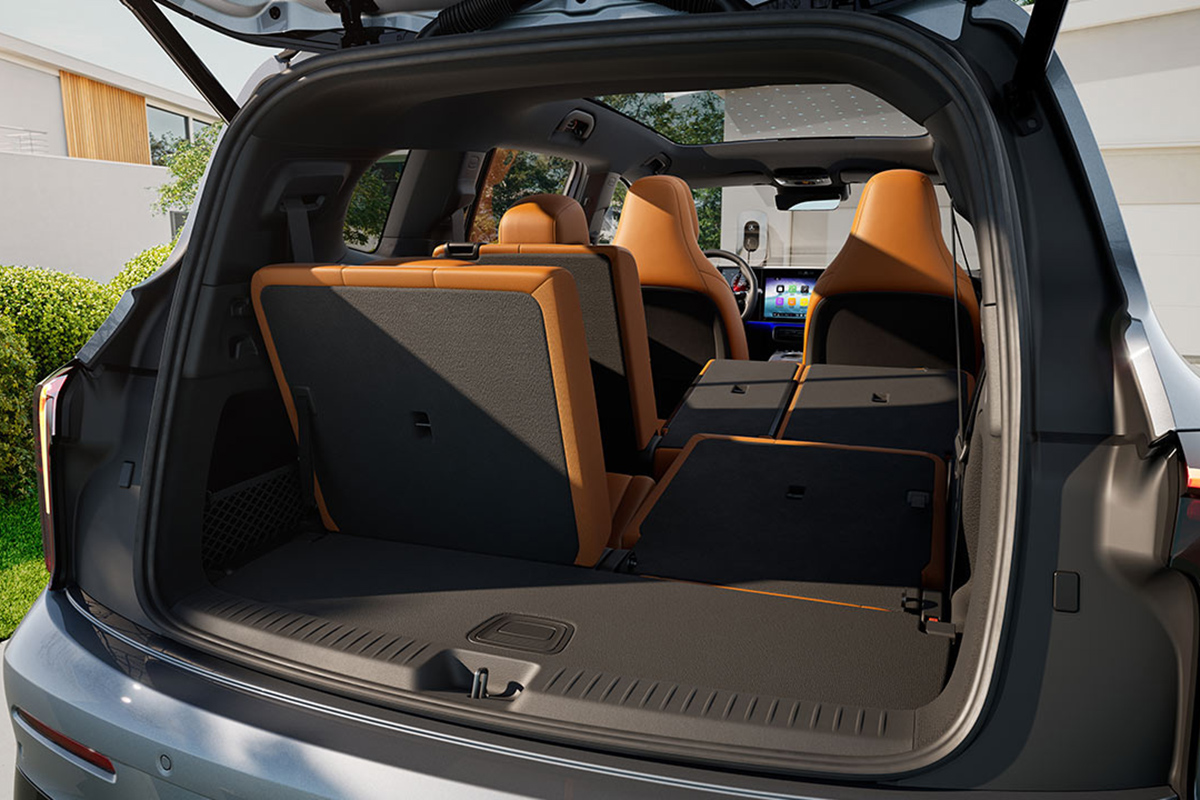 Geoeffneter Kofferraum eines silbernen SUV mit umklappbaren Ruecksitzen in Braun und Schwarz. Sichtbar sind der erweiterte Laderaum, die Innenverkleidung und Teile des Cockpits im Hintergrund.