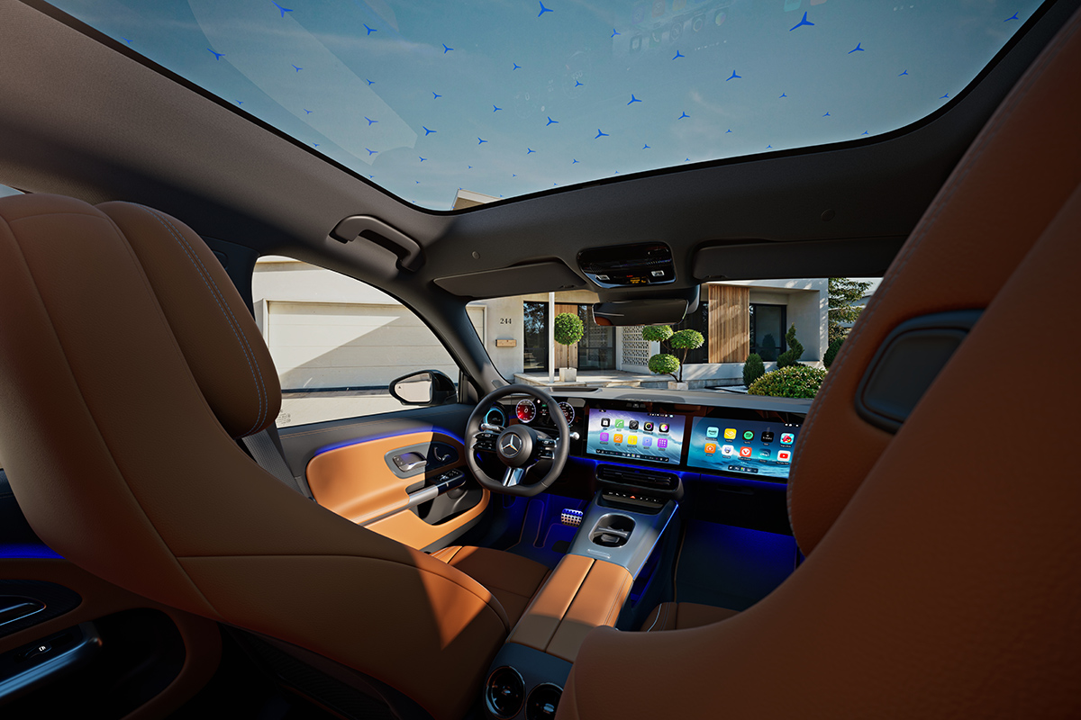 Innenraum eines Mercedes SUV mit braunen Sitzen, grossem Display und blauem Ambientelicht, gesehen durch das Panoramadach mit Muster, waehrend das Fahrzeug vor einem modernen Haus steht.