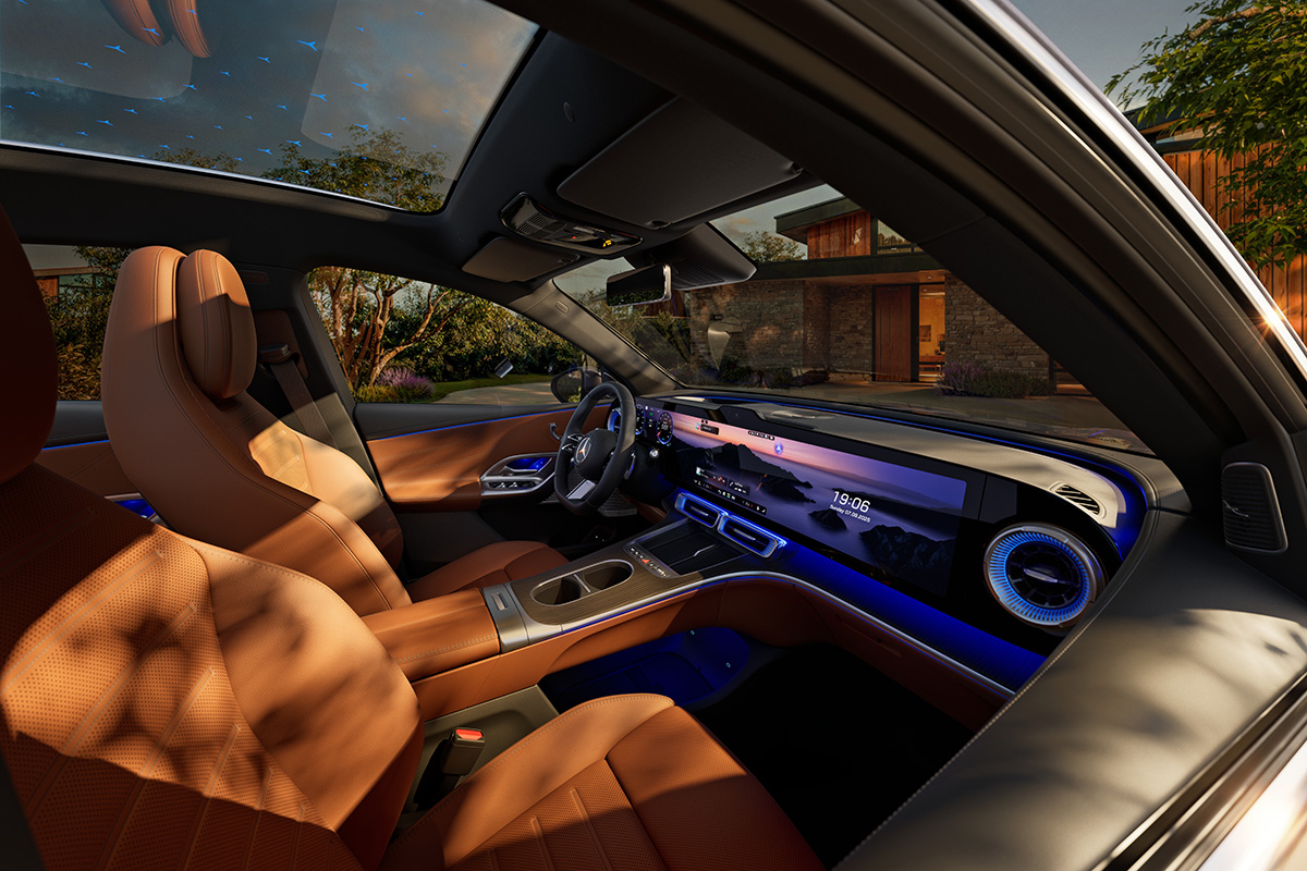 Innenraum eines modernen Mercedes mit braunen Ledersitzen, grossem Display, Ambientebeleuchtung und Panoramadach, aufgenommen bei warmem Abendlicht vor einem Haus.