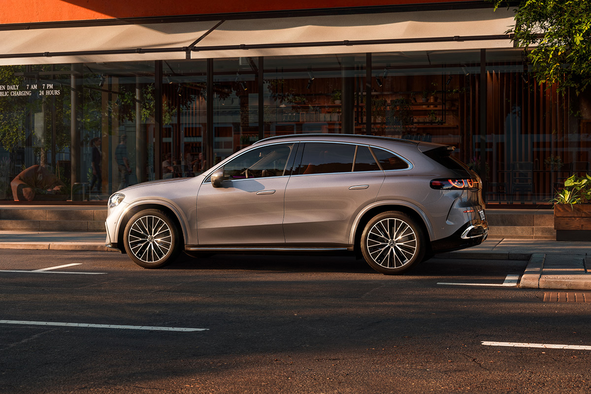 Silberner SUV in Seitenansicht steht an einer stadtlichen Strasse. Sichtbar sind die schlanke Fensterlinie, LED‑Rueckleuchten, schwarze Felgen und die klare, moderne Form der Karosserie.