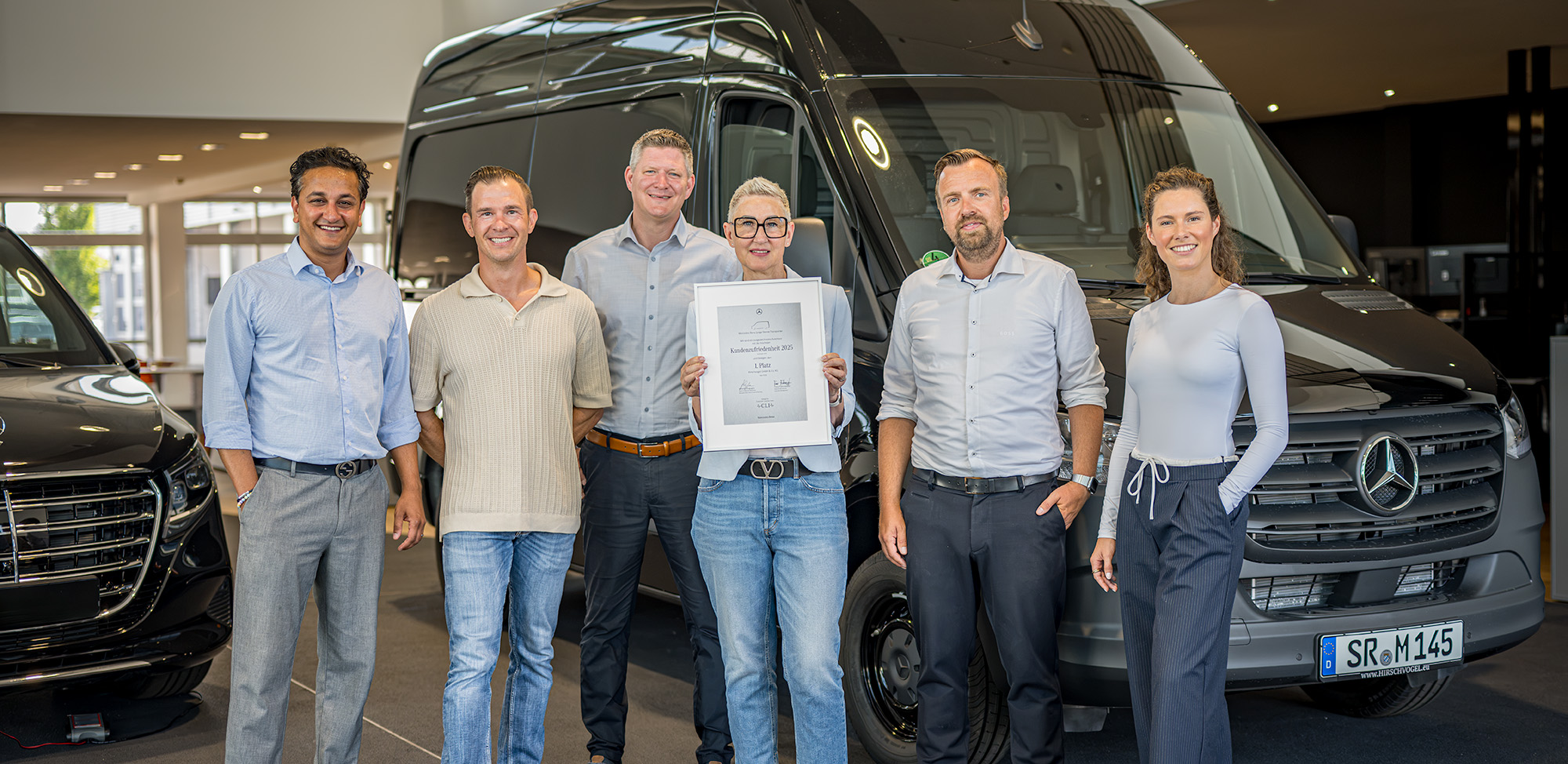 Strahlend vor moderner Kulisse: Das Team Nutzfahrzeuge Gebrauchtwagen präsentiert sich gemeinsam im Showroom – von links Aron Kumar (Verkauf und Einkauf Nutzfahrzeuge Gebrauchtwagen), Dimitrij Polischuk (Verkauf Nutzfahrzeuge Gebrauchtwagen), Michael Rosenhammer (Verkauf Nutzfahrzeuge Gebrauchtwagen), Anita Greiner (Verkauf Nutzfahrzeuge Gebrauchtwagen), Normen Todt (Standortverantwortlicher Plattling und Teamleiter Verkauf) und Antonia Kilger (Geschäftsführerin).