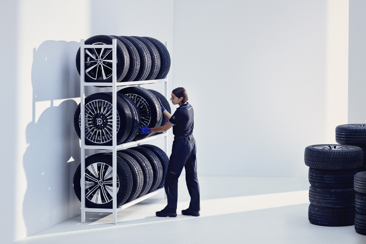 Zeigt eine Mitarbeiterin beim einlagern der Autoreifen.