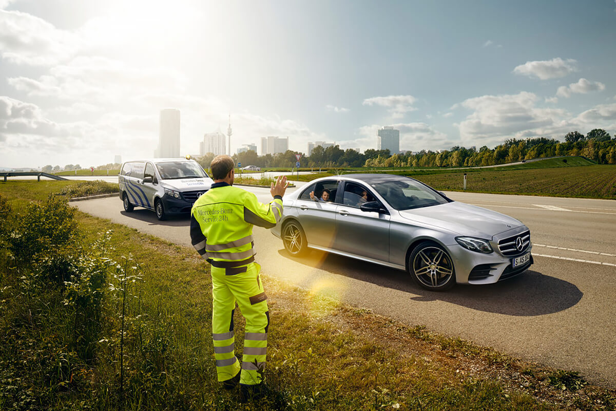 Zeigt einen Pannenmitarbeiter mit zwei Fahrzeugen