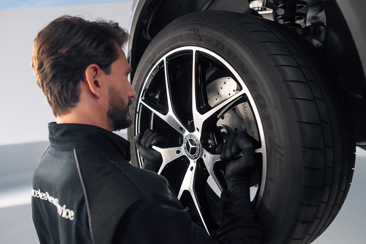 Mitarbeiter wechselt die Reifen am Fahrzeug