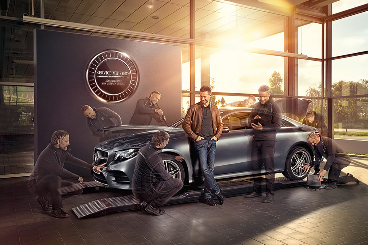 Mitarbeiter und Kunden stehen um das Fahrzeug.